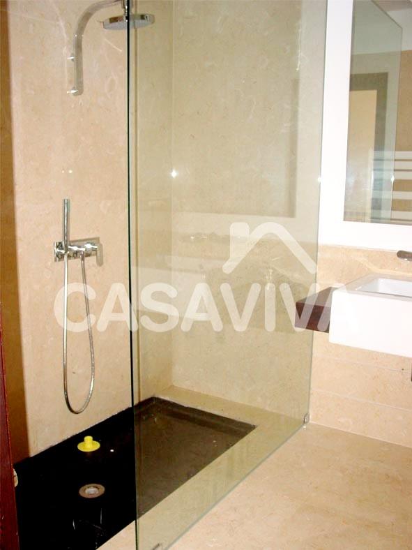Móvel de casa de banho em madeira com lavatório encastrado.Divisória de base de duche em vidro temperado.