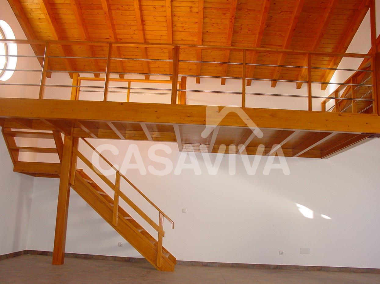 Mezanine em piso superior com estrutura e escadas de acesso em madeira e guarda corpos metlico.