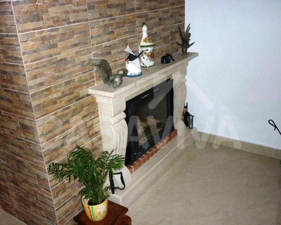 Sistema de recuperao de calor e revestimento em mosaicos sobre o paramento na sala de estar.
